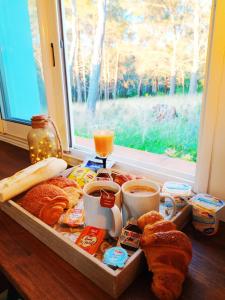 a tray of bread and coffee and a window at A l'Orée des pins - Gite indépendant avec baignoire balnéo et Home Cinéma en sup - Voir info de l'hôte in Cuges-les-Pins
