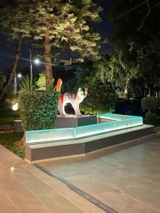 فندق ميرادا في أثينا: مقعد في حديقة مع نافورة في الليل