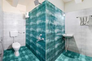 a bathroom with a shower and a toilet and a sink at Via Chaitanya Inn in Pune