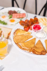 a white plate with breakfast foods on a table at Azamat Hotel in Astana