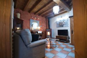 ein Wohnzimmer mit einem Sofa und einem TV in der Unterkunft El Balconcillo-Los Sitios de Aravalle in Umbrías