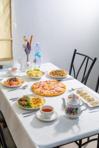 Azamat Hotel في أستانا: طاولة عليها العديد من أطباق الطعام