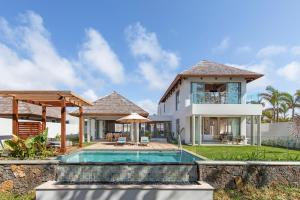 eine Villa mit einem Pool und einem Haus in der Unterkunft Anantara Iko Mauritius Resort & Villas in Blue Bay