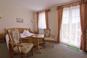 a room with a bed and a table and chairs at Villa Rosa in Karlovy Vary
