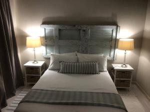 a bedroom with a large bed with two lamps at The Studio in Colchester