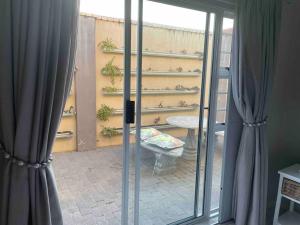 a room with sliding glass doors and a table with potted plants at The Studio in Colchester