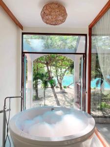 eine Badewanne in einem Zimmer mit einem großen Fenster in der Unterkunft Siam Beach Resort in Ko Chang