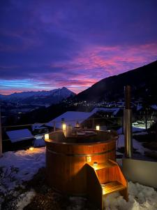 una bañera de hidromasaje en la nieve por la noche en Hotel Fassbind Beausite en Beatenberg