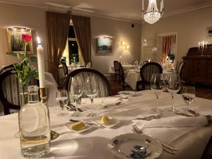 a table with a white table cloth and a bottle of wine at Kastanjelund in Yngsjö