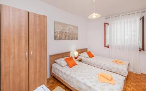 1 dormitorio con 2 camas y armario de madera en Rooms Ivo, en Dubrovnik