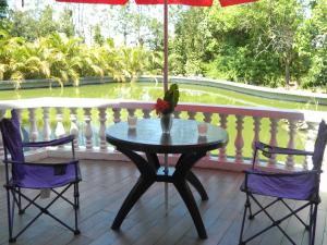 un pájaro sentado en una mesa en un porche en Torch Ginger Homestay en Sultan Bathery