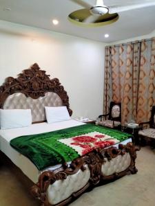 een slaapkamer met een bed met een groene en witte deken bij Sk Travellers Inn in Karachi