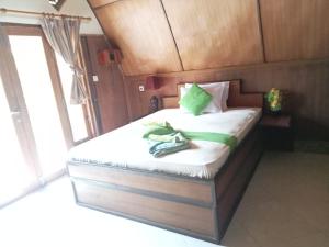 a bedroom with a bed with two shoes on it at Meno Smile Cottages in Gili Meno