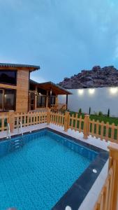 a swimming pool in front of a house at أكواخ ريف الطائف in As Sayl aş Şaghīr