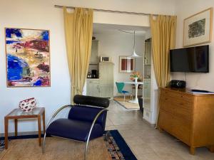 ein Wohnzimmer mit einem TV, einem Sofa und einem Stuhl in der Unterkunft Ferienwohnung Pfeiffer in Eisenach