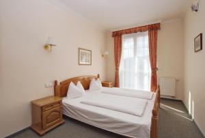 a bedroom with a white bed and a window at Villa Rosa in Karlovy Vary