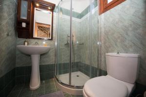 La salle de bains est pourvue de toilettes, d'un lavabo et d'une douche. dans l'établissement Erikousa Villas by CorfuEscapes, à Ereikoússa