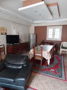 a living room with a table and a couch at فيلا انور يسن ابو كليلة in Zāwiyat al Habbābīyah