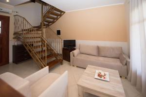 uma sala de estar com um sofá e uma escada em Erikousa Villas by CorfuEscapes em Ereikoússa