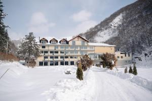 a large building in the snow in front at Apricot Aghveran Resort in Agveran