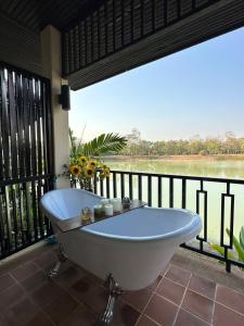 a bath tub on a balcony with a view of a river at Lunarr Star Waterpark by Siris Stars Resort in Ban Mai