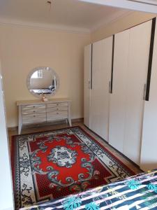- une chambre avec un tapis rouge et un miroir dans l'établissement فيلا انور يسن ابو كليلة, à Zāwiyat al Habbābīyah