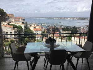 uma mesa e cadeiras numa varanda com vista para a água em Las Delicias ROSES em Roses