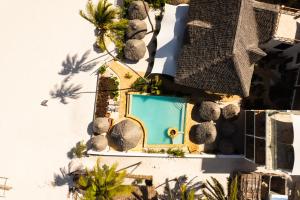 Cette chambre offre une vue sur une maison dotée d'une piscine bleue. dans l'établissement Alladin Boutique Beach Hotel and SPA Zanzibar, à Matemwe