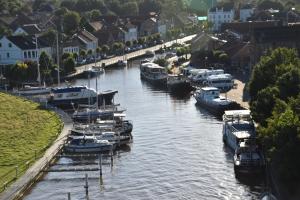 a group of boats are docked in a river at Ferienwohnung Jaeschke_ 25669 in Weener