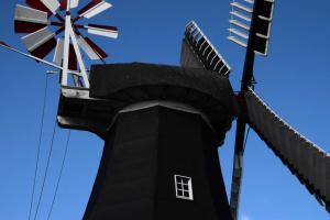 een zwarte molen met een windmolen erop bij Ferienwohnung Jaeschke_ 25669 in Weener