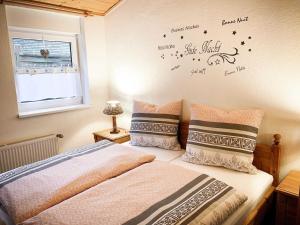 een slaapkamer met een bed met woorden op de muur bij Ferienwohnung Jaeschke_ 25669 in Weener