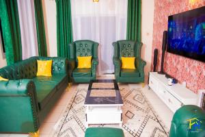 a living room with two green couches and a tv at Lux Suites Mtwapa Luxury Apartments in Mtwapa