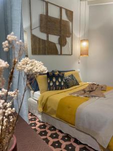 una camera da letto con letto, lenzuola e cuscini gialli di Villa Marengo Guest House a Spinetta