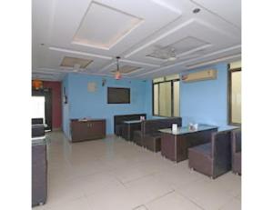 a room with blue walls and tables and chairs at Hotel Shivam Fort View, Chittorgarh in Chittaurgarh