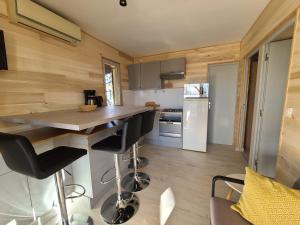 - une cuisine avec une île dans une petite maison dans l'établissement VILLAGE DE GITES LA TRUFFIERE, à Orliaguet