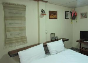 een slaapkamer met een bed en een grote poster aan de muur bij The Sunrise Beach Cafe and Guesthouse in Ban Tha Khoi