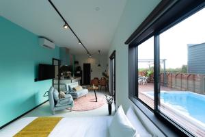 a bedroom with a large window and a swimming pool at クリスタルパーク久松 in Miyako Island