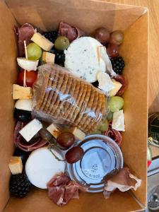 a box filled with different types of cheese and grapes at Robin's Nest in Donegal