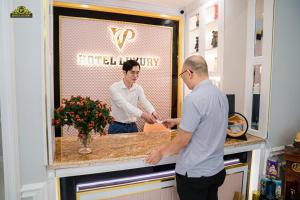deux hommes debout à un comptoir dans un salon de coiffure dans l'établissement VP Hotel Luxury, à Hanoï 75 autres photos