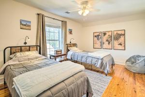 Un dormitorio con dos camas y un ventilador de techo. en Greenville Escape with Deck and Fire Pit!, en Greenville