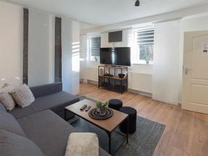 uma sala de estar com um sofá e uma mesa em Dangaster Nest, Ap Hinnerk, FeWo Vermittlung Nordsee em Dangast