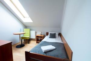 1 dormitorio con 1 cama y 1 mesa con silla en Noclegi Grill Solo, en Sandomierz