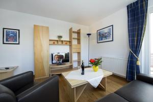 ein Wohnzimmer mit einem Sofa und einem TV in der Unterkunft Haus Südstrand in Göhren