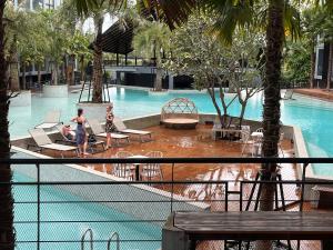 a swimming pool with two people in a resort at Kamala Beach P72 Exclusive Junior Suite in Bang Tao Beach
