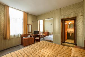 1 dormitorio con cama, escritorio y lavamanos en Family Hotel Chiplakoff, en Burgas