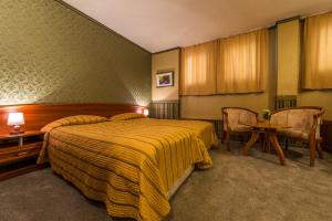 a bedroom with a bed and a table and chairs at Family Hotel Chiplakoff in Burgas +15 photos