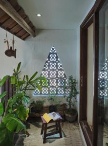 - une fenêtre dans une pièce avec des plantes et une table dans l'établissement Barbados Cherry Villa, à Hội An
