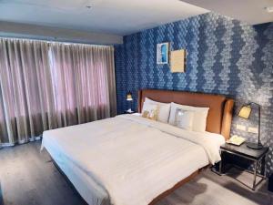 a bedroom with a large bed and a blue wall at 安庭台北商旅 in Taipei