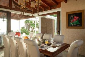 a dining room with a table and white chairs at Villa Pueblo in Nafplio