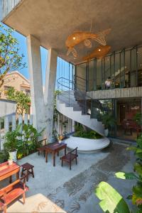 a building with benches and a staircase in a courtyard at Barbados Cherry Villa in Hoi An